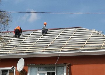 Коммунальщики ремонтируют поврежденные обстрелами окна и кровли Коммунальщики ремонтируют поврежденные обстрелами окна и кровли