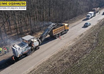 На подъездной дороге к поселку Березовка устраивают выравнивающий слой асфальта